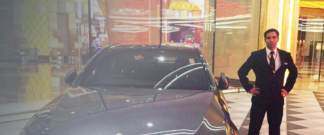 CHON close protection officer standing beside a luxury car